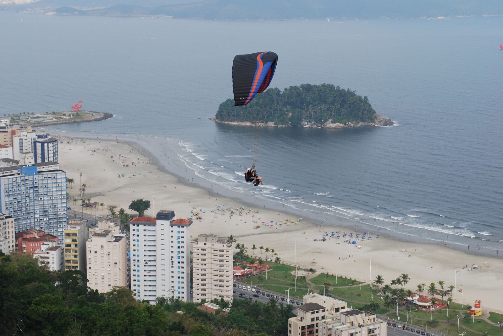 Parapente em voo sobre a praia e o mar
